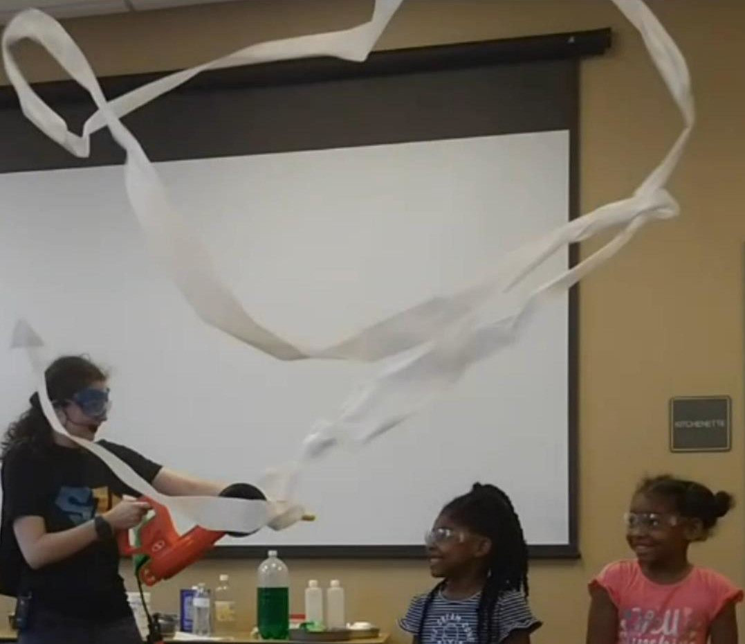 A woman demonstrating science to children